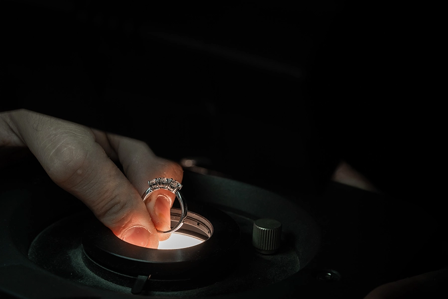 Esame di un anello in metallo bianco con illuminazione e ingrandimento